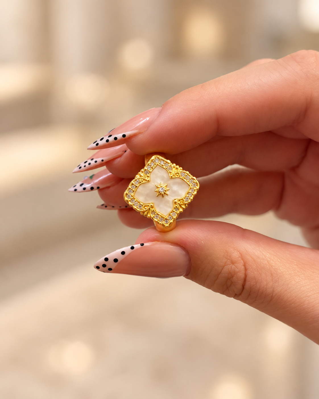خاتم الزهرة البيضاء بإطار ذهبي مرصّع
White Floral Ring with Sparkling Gold-Tone Frame
